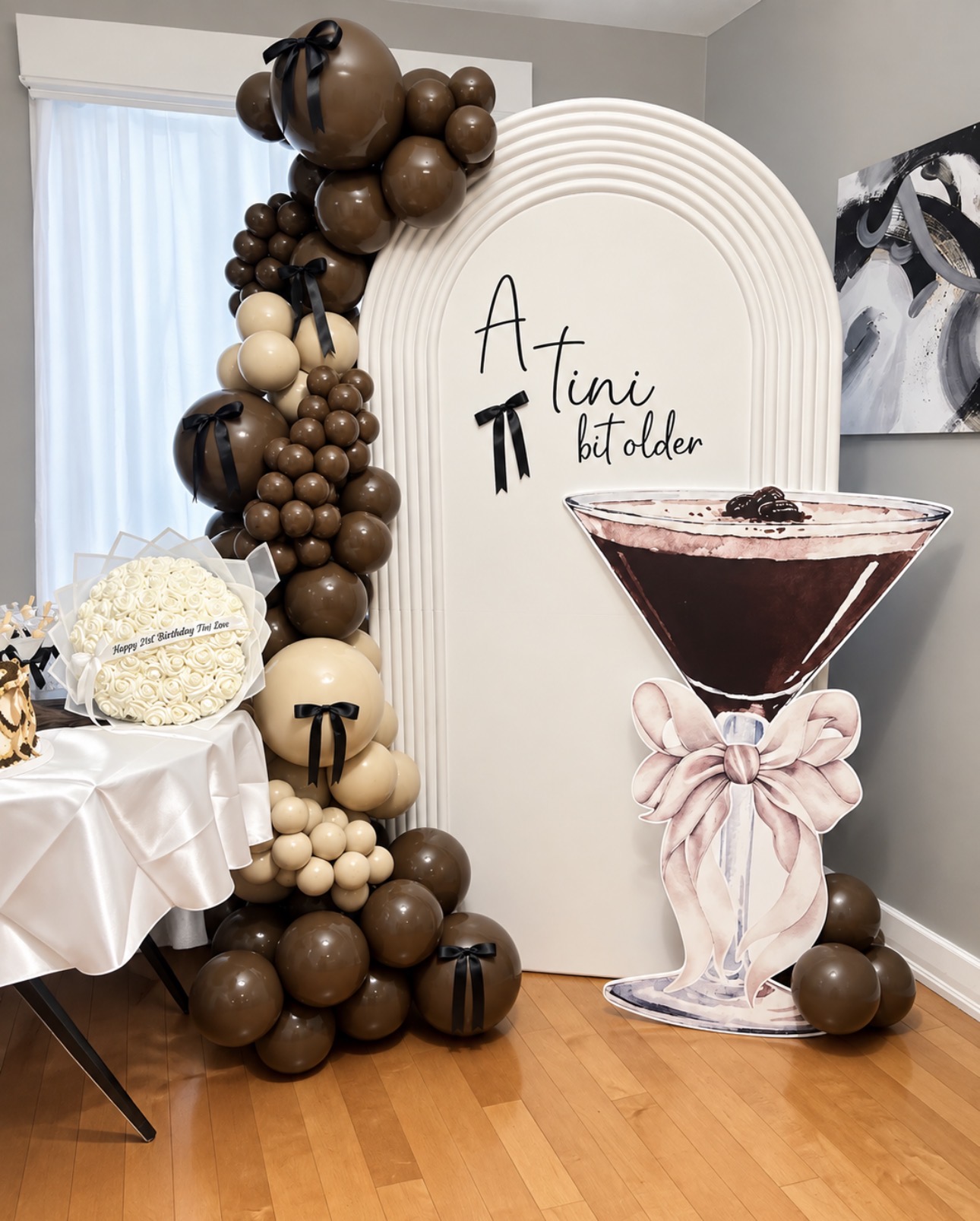Cream half ripple arch with brown and cream balloons and a cocktail cutout